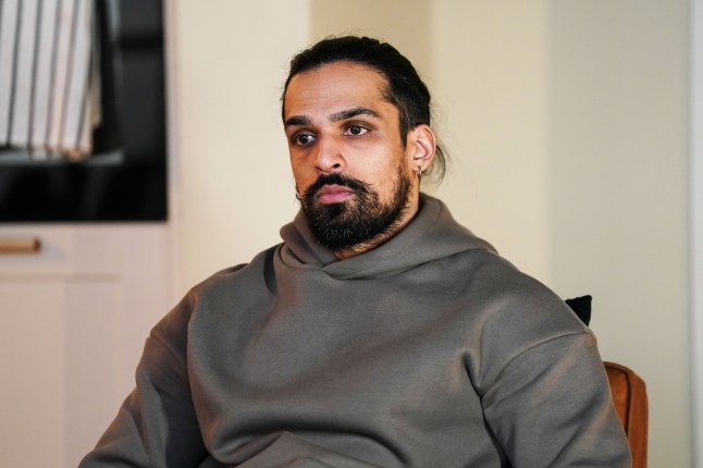 Ravi looks upset as he sits alone in EastEnders