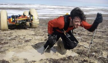 guy pulling sled through mud