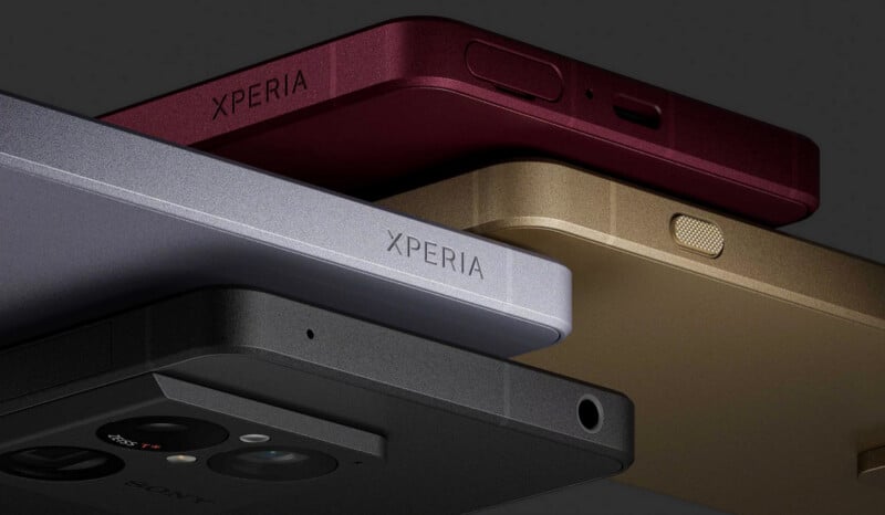 Close-up of four Sony Xperia smartphones stacked in different colors: silver, black, gold, and burgundy, showing their edges, camera lenses, and branding.