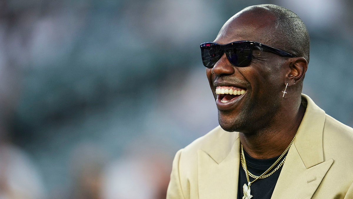 Former NFL player Terrell Owens standing on the sideline at Paycor Stadium
