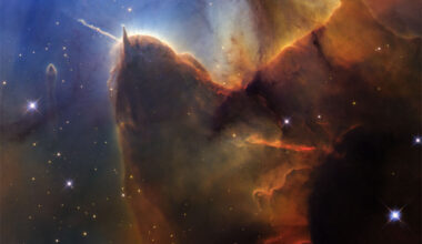 A field of stars on the left is mirred by a wall of
opaque brown dust on the right. Jutting out from the wall is
a long pillar with a rounded end that has a prominent light-
colored jet emanating toward the upper left. The stellar 
background toward the upper left is dark blue.
Please see the explanation for more detailed information.