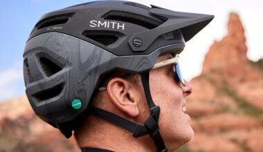 a man wearing the Smith Payroll Twiceme helmet with desert rocks in the background.