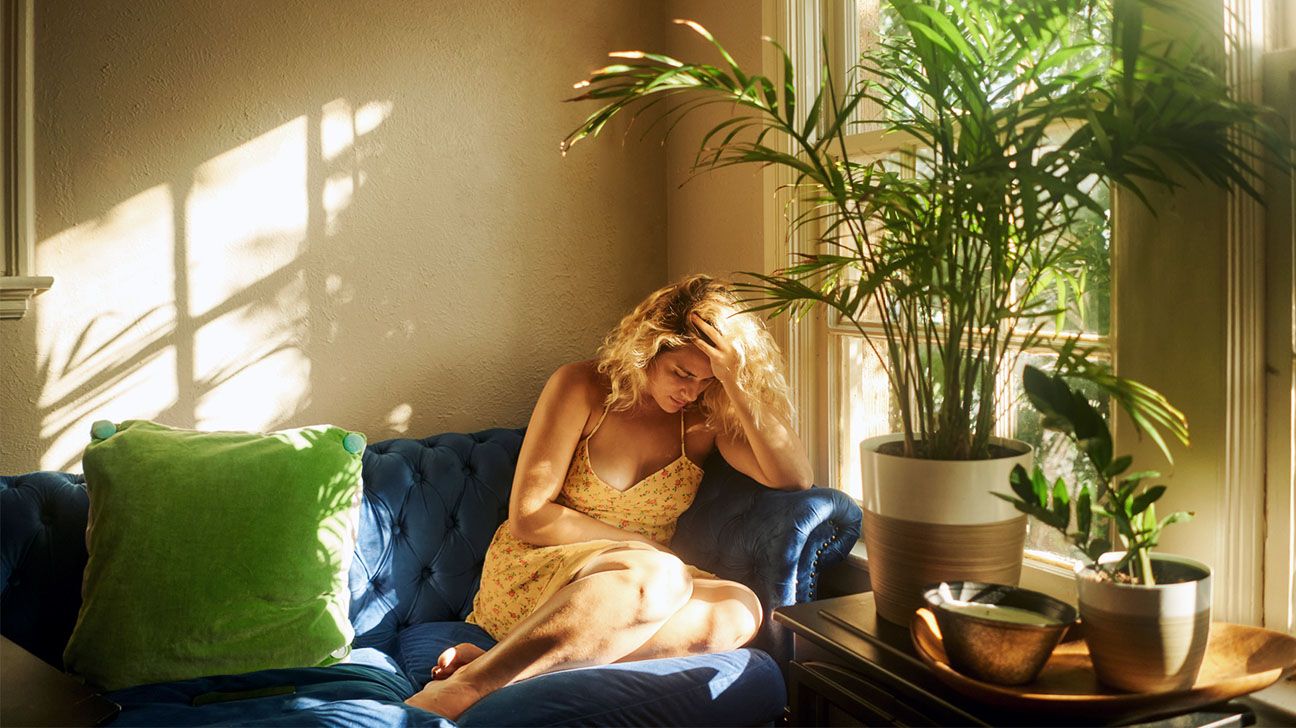 Female on couch with migraine headache