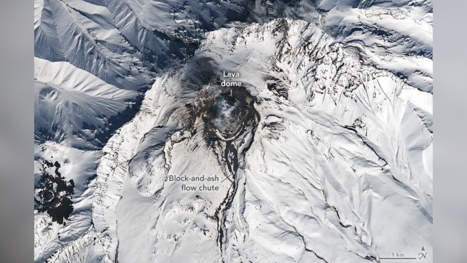 snowy volcano with dark scars on the landscape