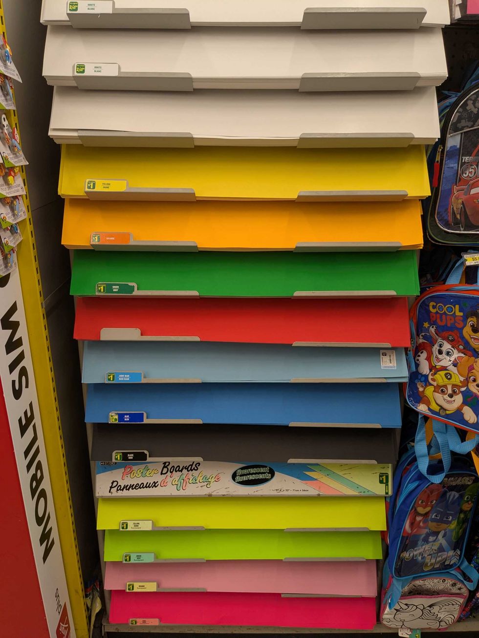 A rack of colourful poster boards at Dollarama