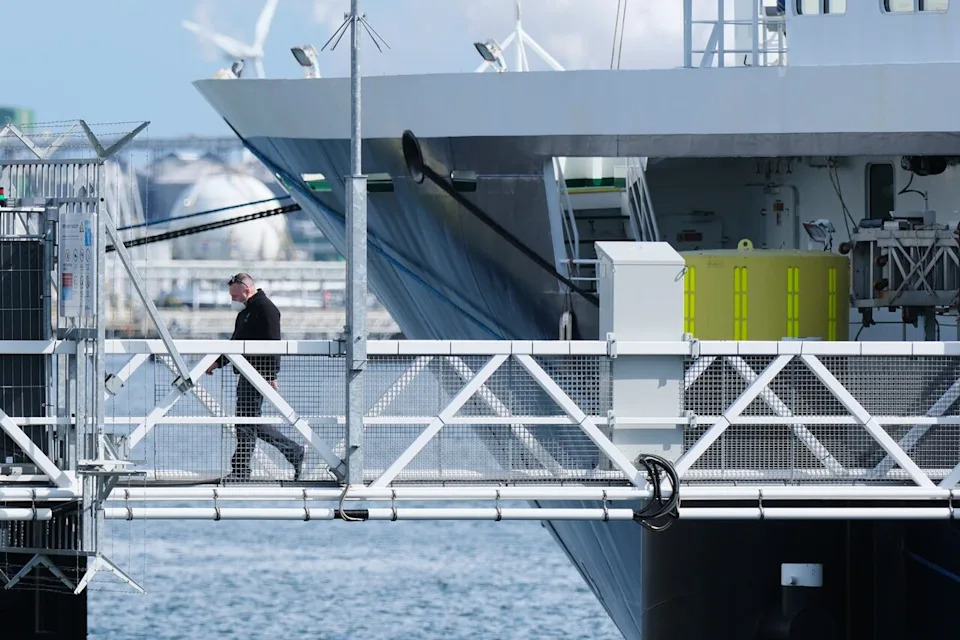 A crew member disembarks the MV Hondius cruise ship after its arrival at the Port of Rotterdam, Netherlands, Monday, May 18, 2026. (AP Photo/Patrick Post)