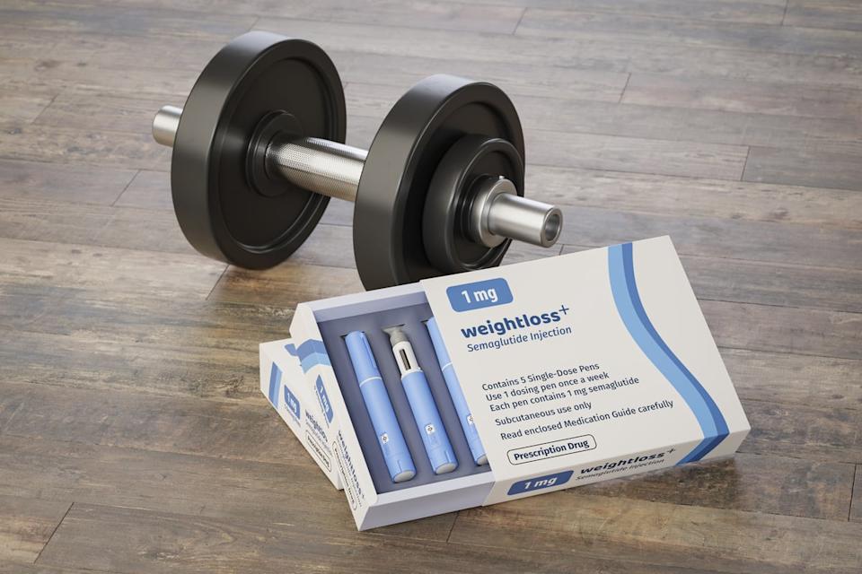 A barbell sits next to package of GLP-1 weight loss drugs on a gym floor.