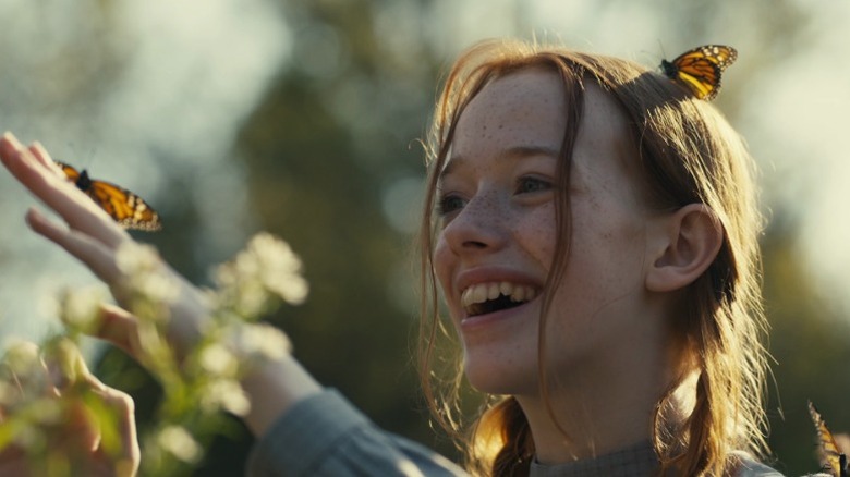 Anne (Amybeth McNulty) smiling while butterflies land on her on Anne with an E S2E1