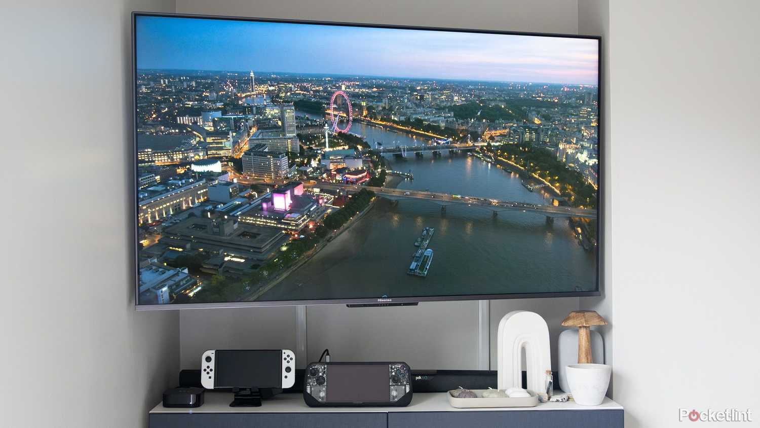 A TV with gaming handhelds and an Apple TV 4K.
