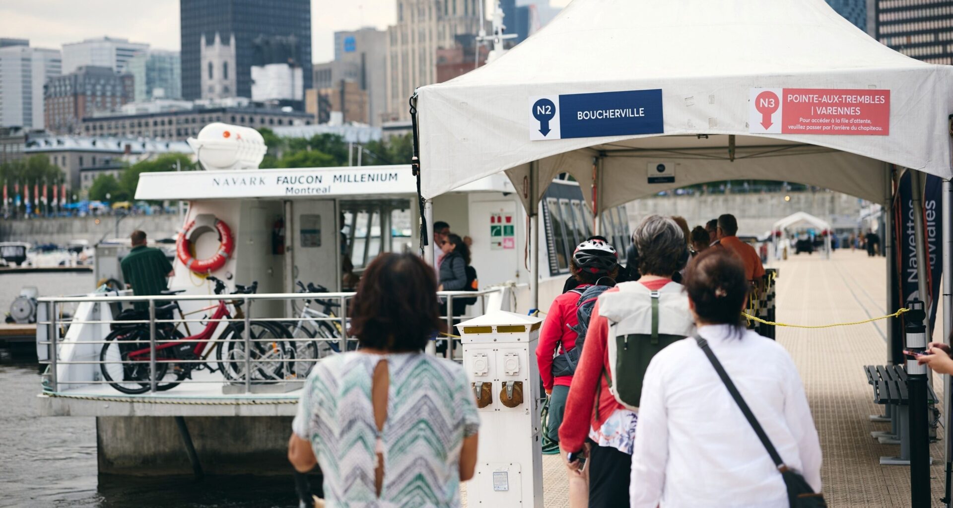 People line up on a port wharf for a boat shuttle.