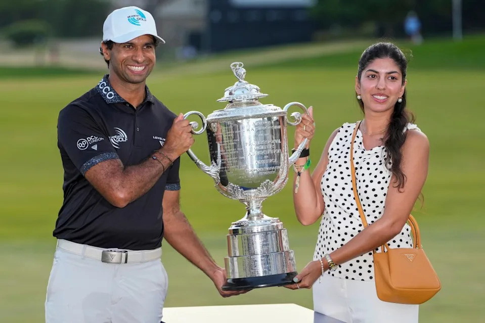 Aaron Rai, of England, and wife Gaurika Bishnoi hold the Wanamaker Trophy after winning the PGA Championship golf tournament at Aronimink Golf Club, Sunday, May 17, 2026. AP Photo/Frank Franklin II