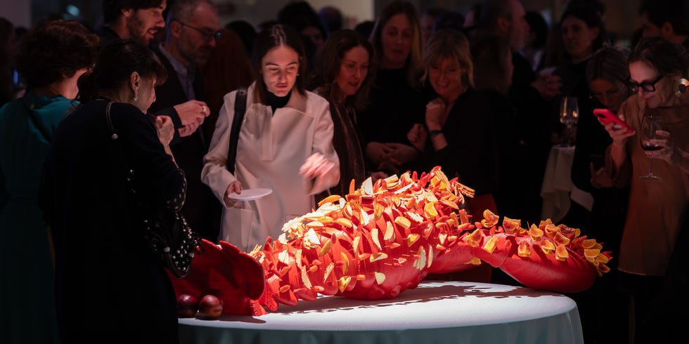 A vibrant lobster centerpiece surrounded by guests at an event.