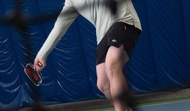 David Summers pictured playing pickleball behind a net.