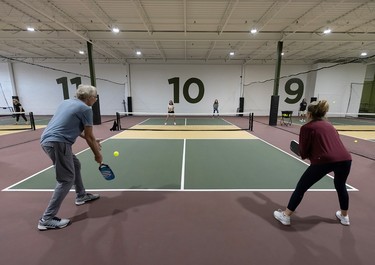 Four people playing a game of pickleball.