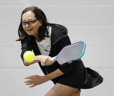 Susie Sheffman swinging a pickleball racket as a ball passes in front of her.