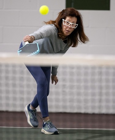 Caren Birnbaum wearing goggles and playing pickleball.