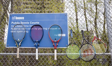Tennis racquets on a fence.