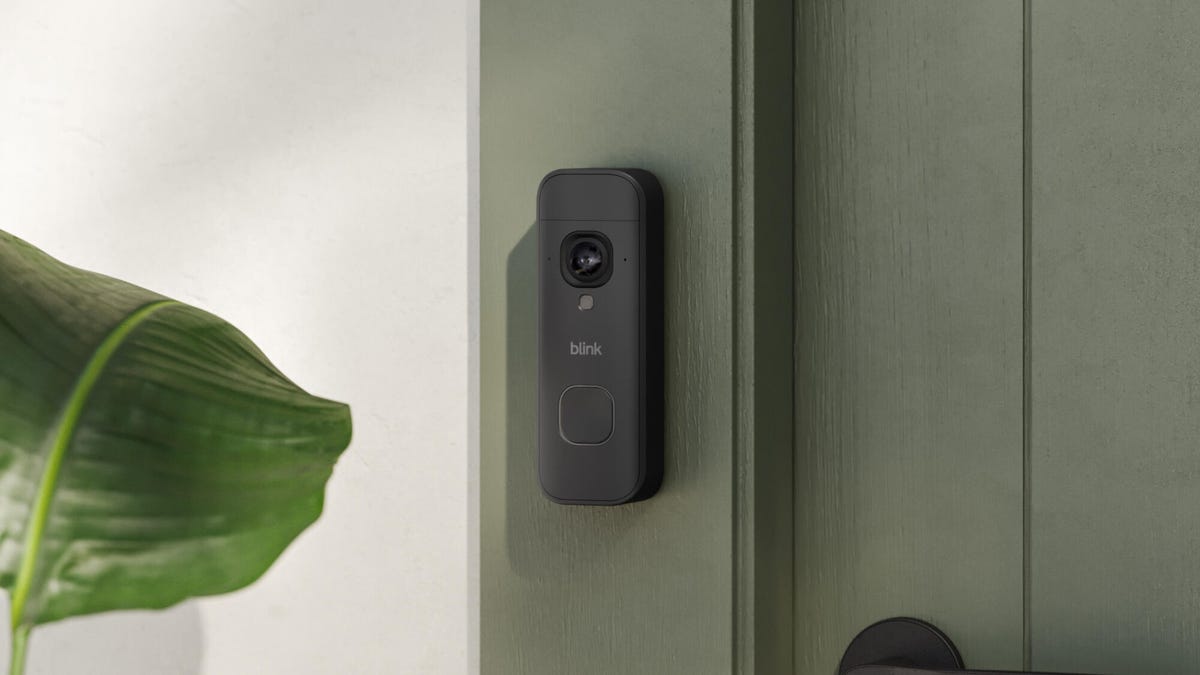 Blink's new battery doorbell on a gray door frame.