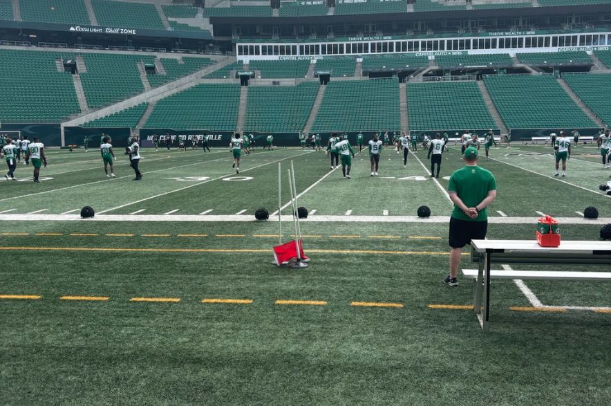 Saskatchewan Roughriders players are spread across the field during the final day of training camp at Mosaic Stadium in Regina. Coaches observe from the sideline as players participate in drills ahead of final roster cuts.