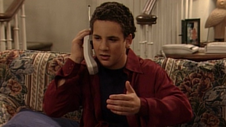Cory (Ben Savage) sitting on the couch and talking on the phone on Boy Meets World S3E5