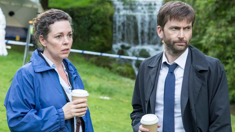 Olivia Colman as Ellie and David Tennant as Alec holding coffee cups and looking severe in Broadchurch