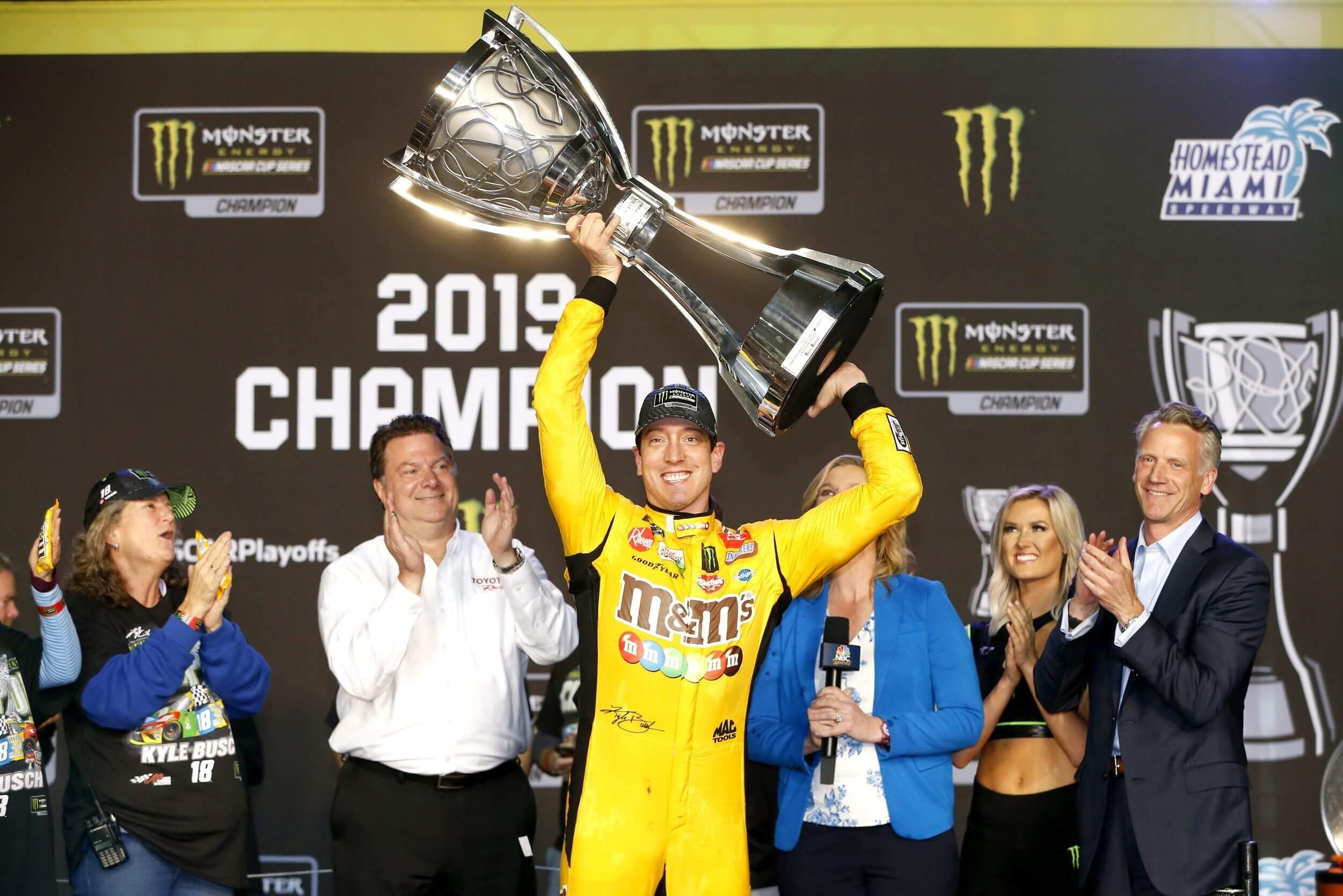 Kyle Busch, driver of the No. 18 M&M's Toyota, hoists the trophy after winning the Monster Energy NASCAR Cup Series Ford EcoBoost 400 at Homestead Speedway on November 17, 2019, in Homestead, Florida