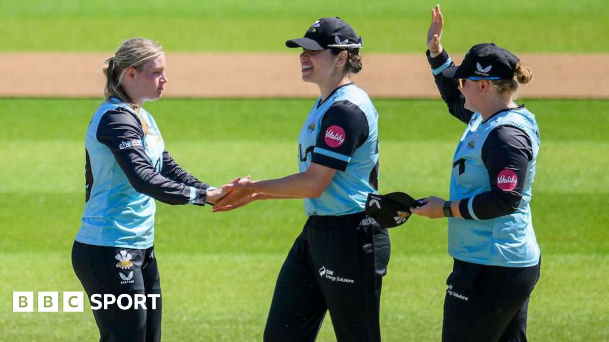 Surrey's Ryana MacDonald-Gay (left) celebrates a wicket with teammates