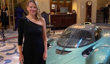 Jennie Gow stands in a black dress in front of turquoise super car