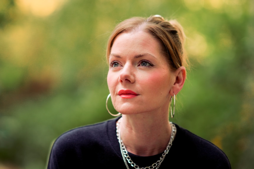 A close up of a woman starring off to the left with a serious look on her face