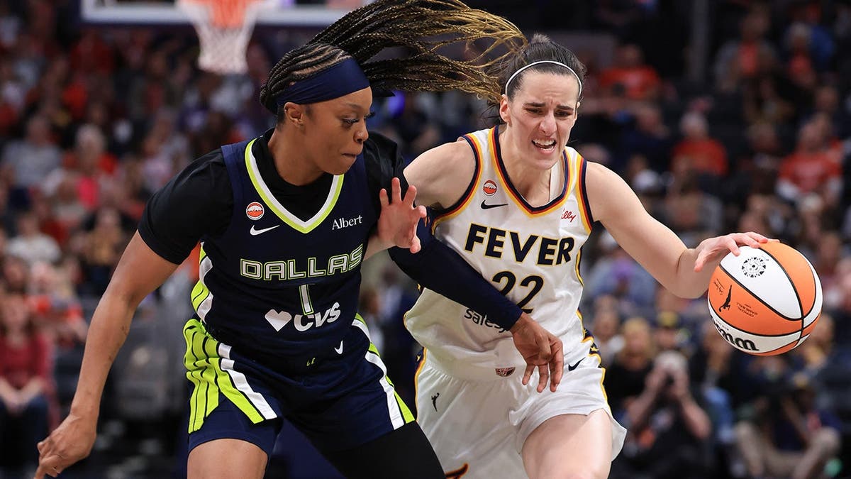Caitlin Clark dribbling basketball against Odyssey Sims at Gainbridge Fieldhouse
