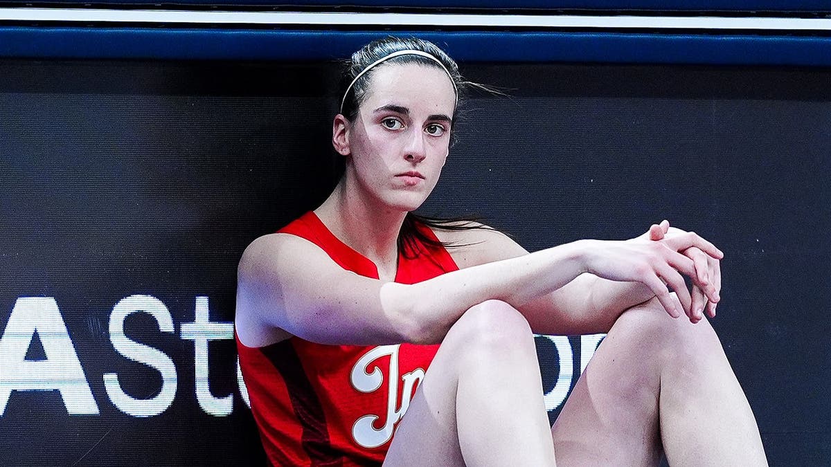 Indiana Fever guard Caitlin Clark standing on basketball court waiting to check into game