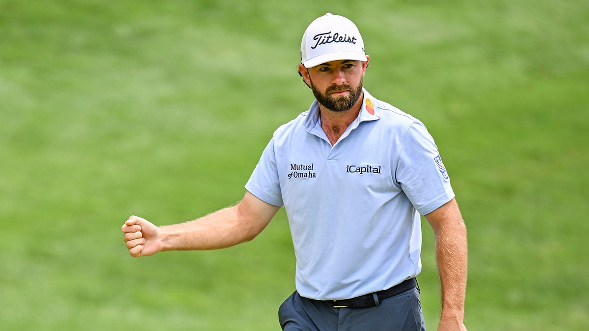 Cameron Young celebrating with a fist pump on the 18th hole green at TPC River Highlands