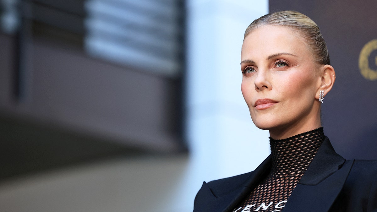 Charlize Theron standing on red carpet at film premiere in Los Angeles