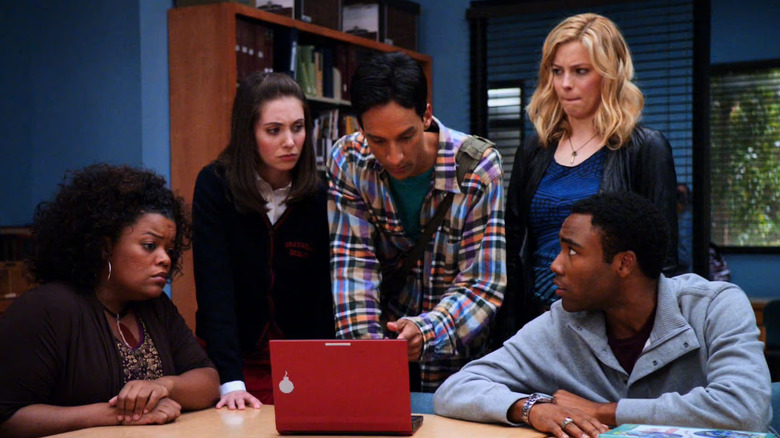 Yvette Nicole-Brown as Shirley, Alison Brie as Annie, Danny Pudi as Abed, Gillian Jacobs as Britta, and Donald Glover as Troy huddled around a laptop in Community
