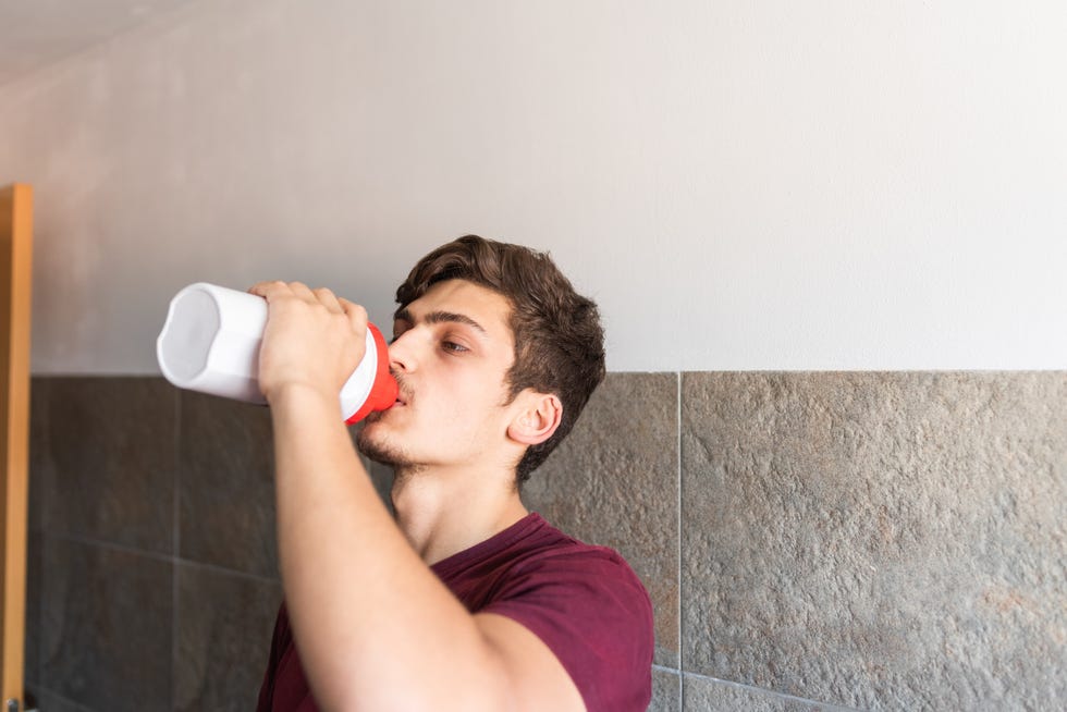 teenager drinking a protein shake after weight training