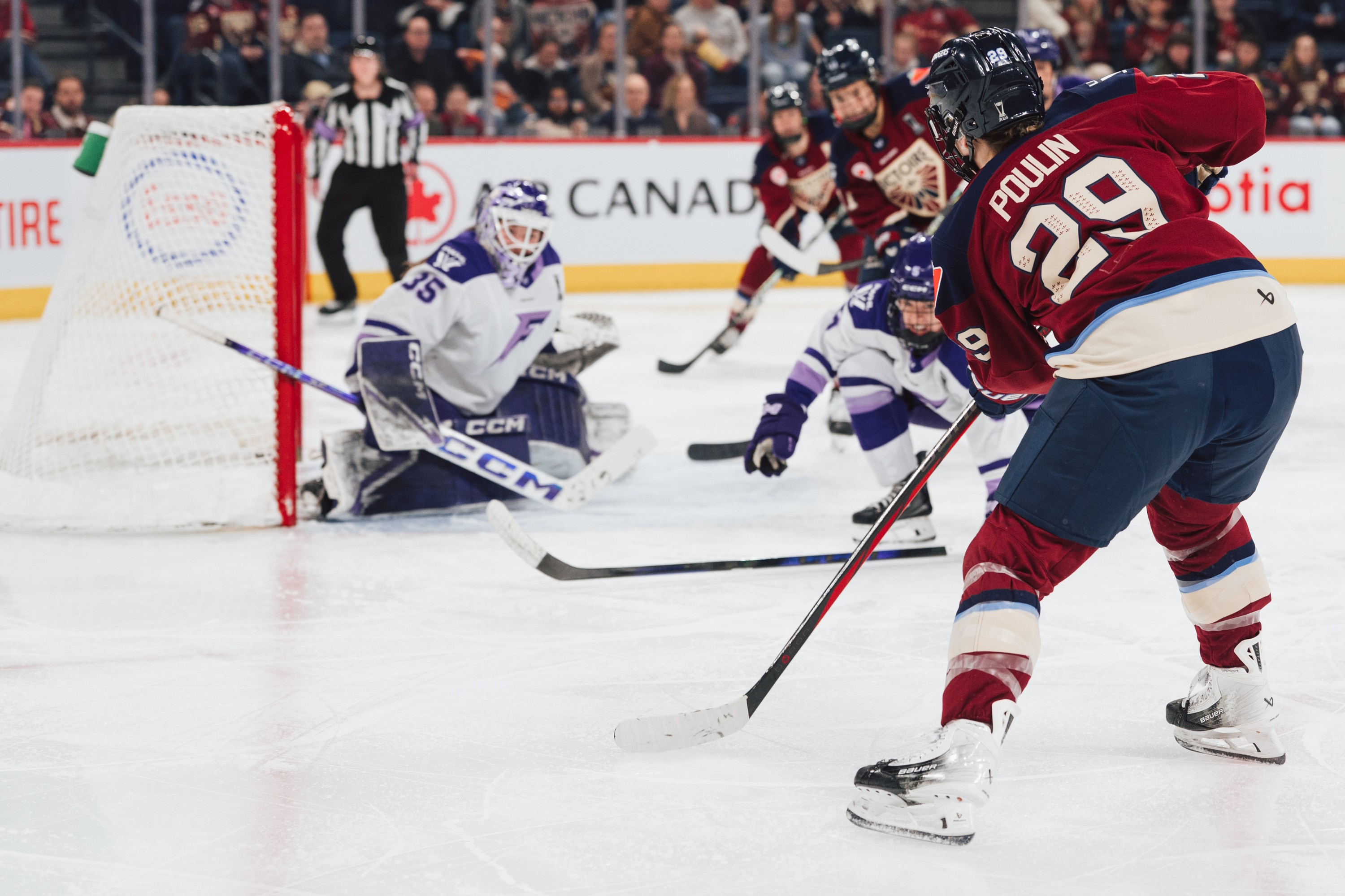 Marie-Philip Poulin takes a shot from the corner of the rink, a sharp angle at the Minnesota net.