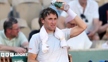 Casper Ruud pours water over his head during a change of ends