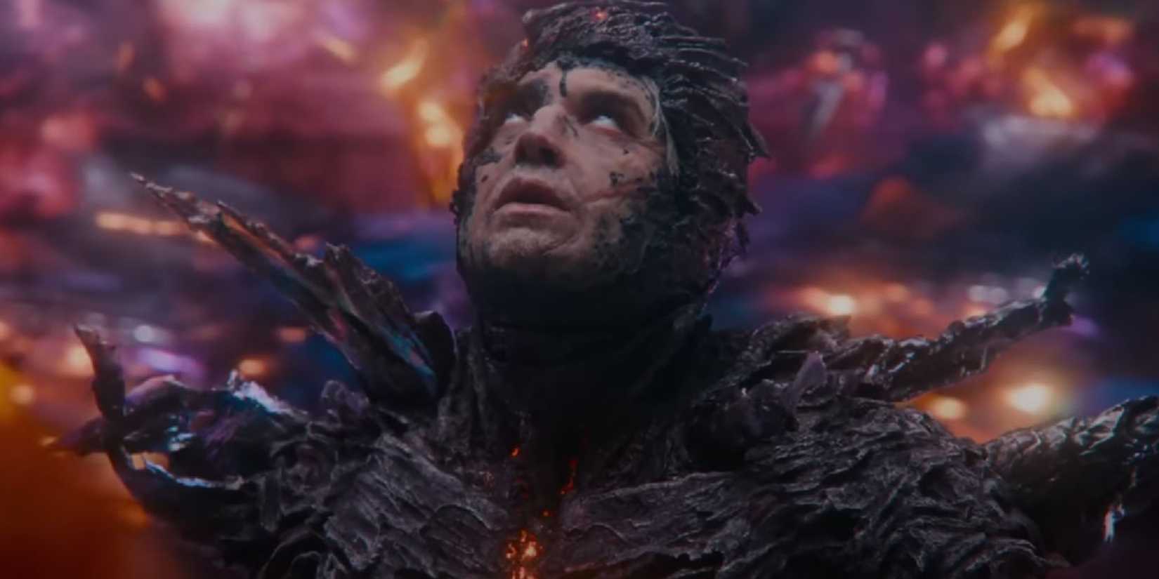 Dark Flash inside a storm with stone-like shards encrusting him, looking up, eyes rolled back, in The Flash