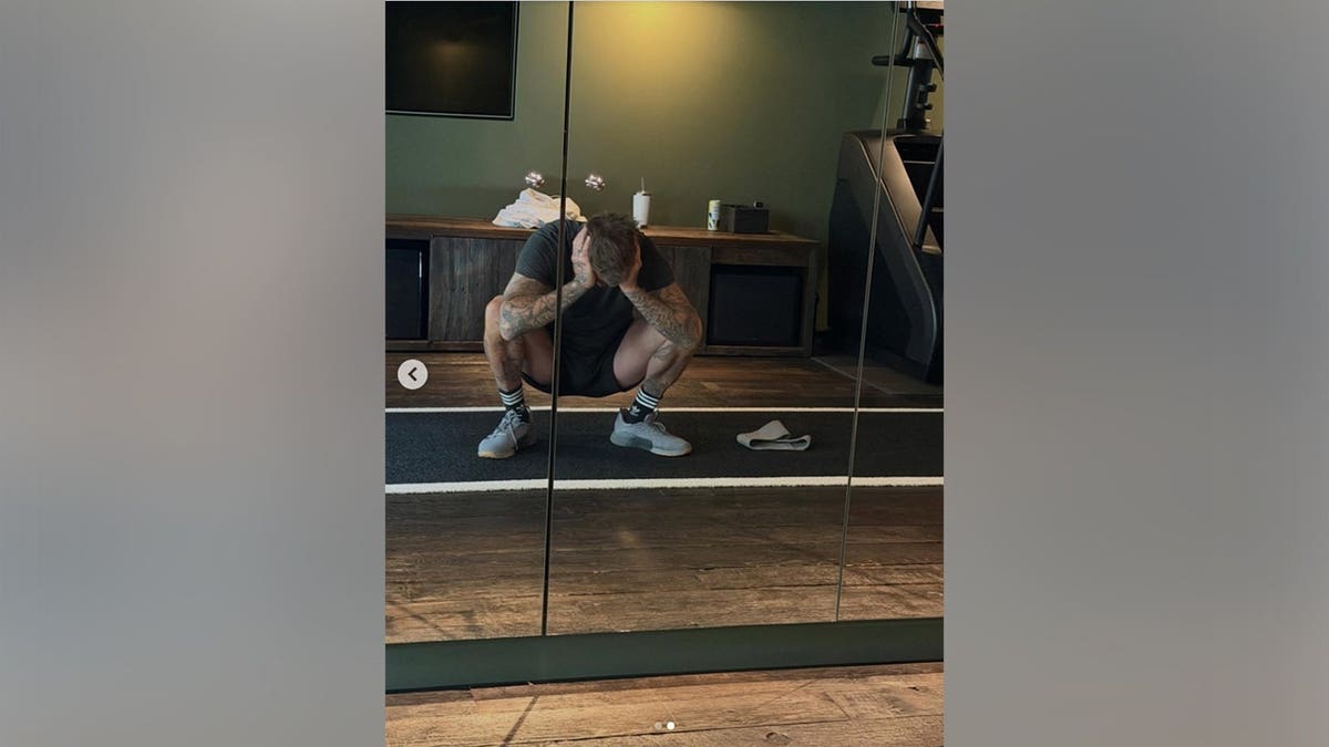David Beckham in the gym with his head in his hands.