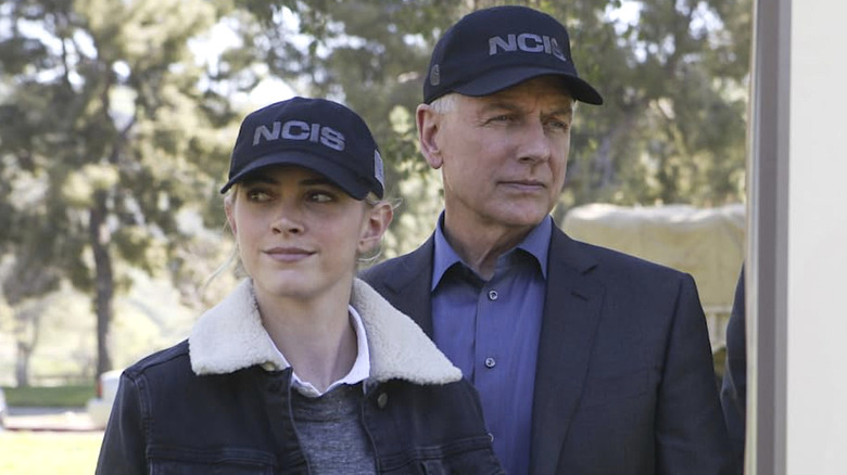 Ellie Bishop and Leroy Jethro Gibbs standing next to each other wearing black NCIS hats in 