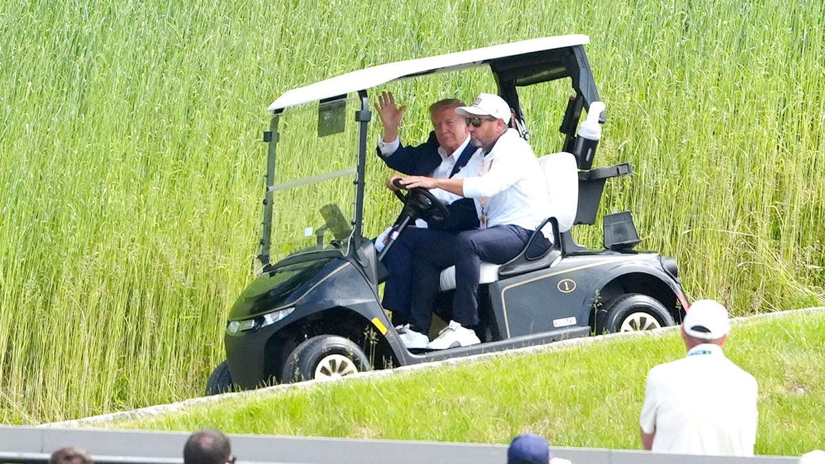 US President Donald Trump riding a golf cart at Trump National Golf Club in Sterling, Virginia