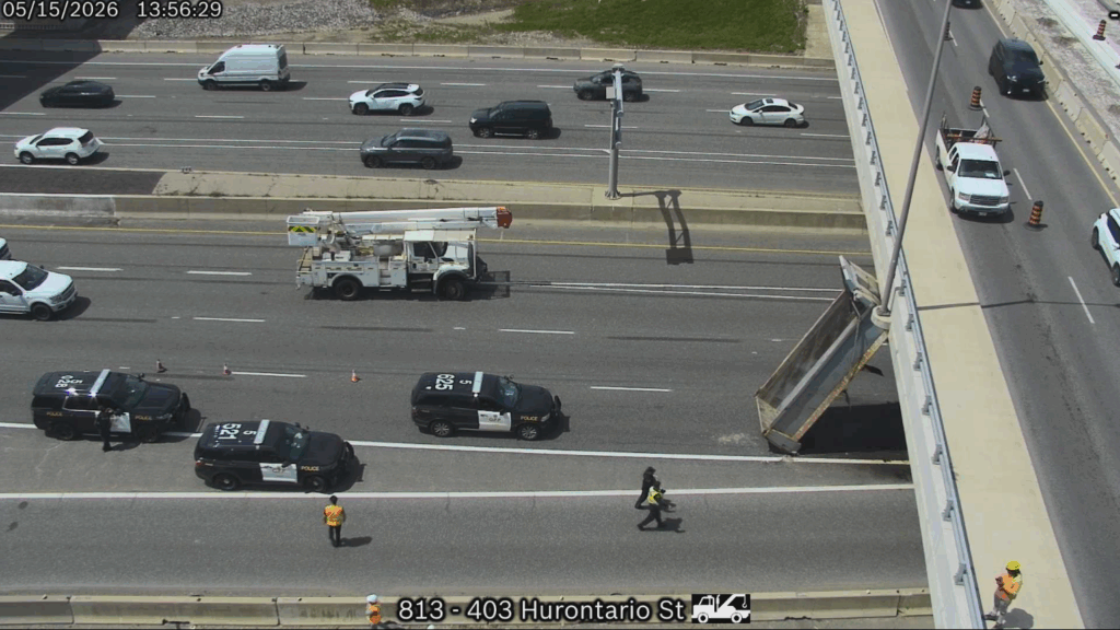 A traffic camera photo shows the box from a dump truck resting against an overpass on Hwy 403 after the truck struck the overpass on May 15, 2026. Credit: Ontario 511