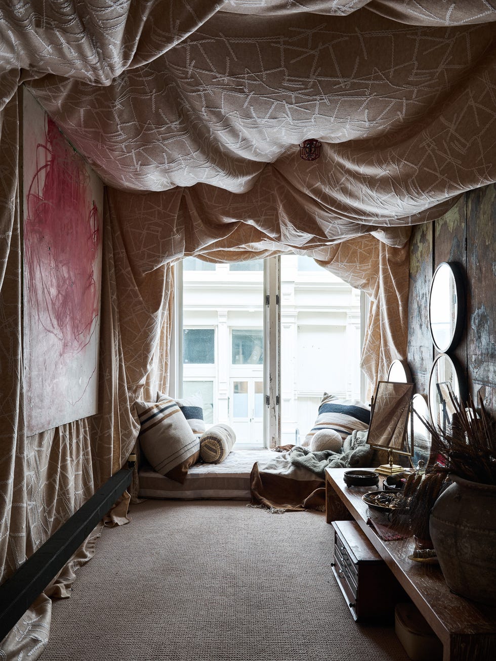 Interior space with draped fabric and a cozy sitting area.