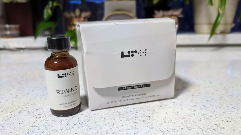 A bottle of LTH Rewind Collagen Elixir next to its packaging on a kitchen counter.