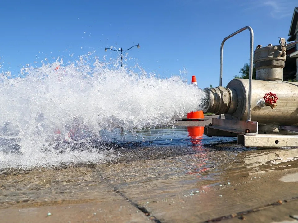 A City of Calgary crew flushes out a water main through an open fire hydrant to clear potential contaminated water following a large water main break near Silverado on Friday, June 2, 2023.