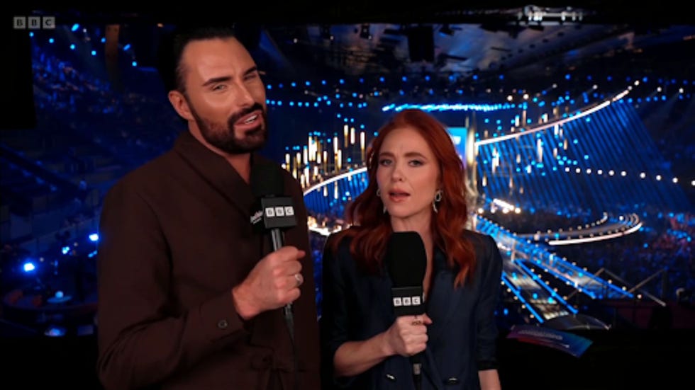eurovision song contest 2026 rylan clark angela scanlon two presenters holding microphones in a brightly lit venue