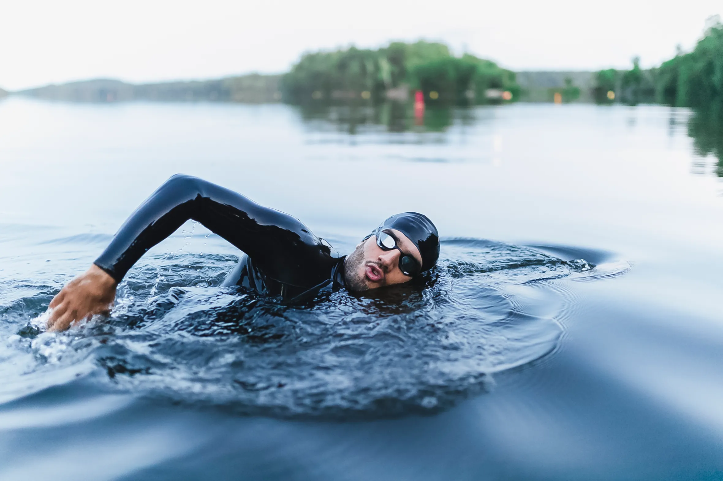 Man splashing water while swimming in a lake.