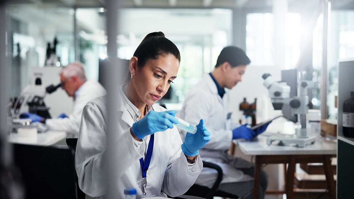 Female scientist holding a vial in a laboratory setting