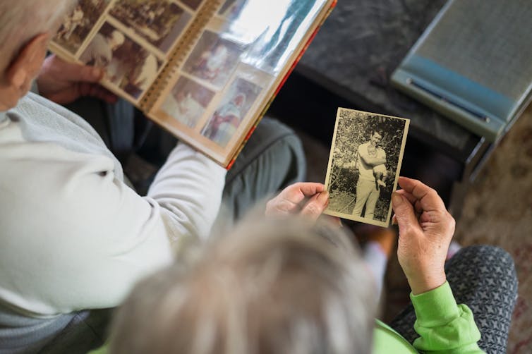 view from above of two people looking at black and white photos in an album