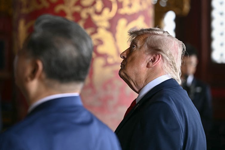 Two men in suits look away from the cabinet.